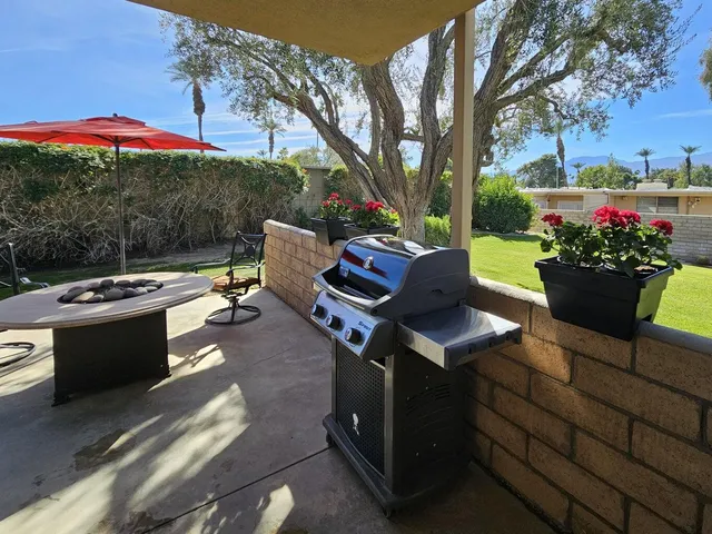 a view of a patio with couches and table and chairs under an umbrella