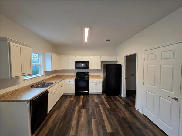 a large kitchen with a stove and refrigerator