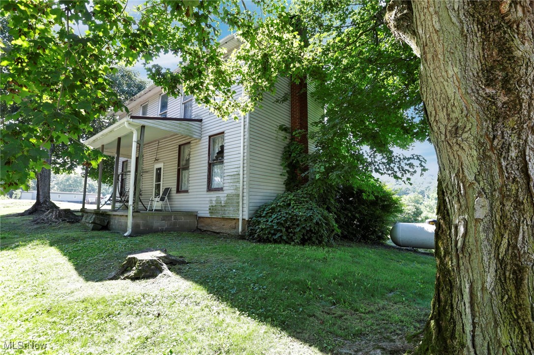21372 Bridgewater Road Quaker City, OH 43773 - Photo 6 of 39 View of side of property featuring a porch and a yard