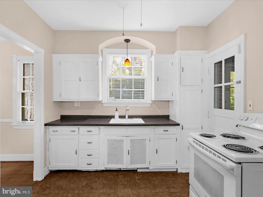 1201 Noyes Drive Silver Spring, MD 20910 - Photo 14 of 35 a kitchen with granite countertop a stove a sink dishwasher and white countertops with wooden floor