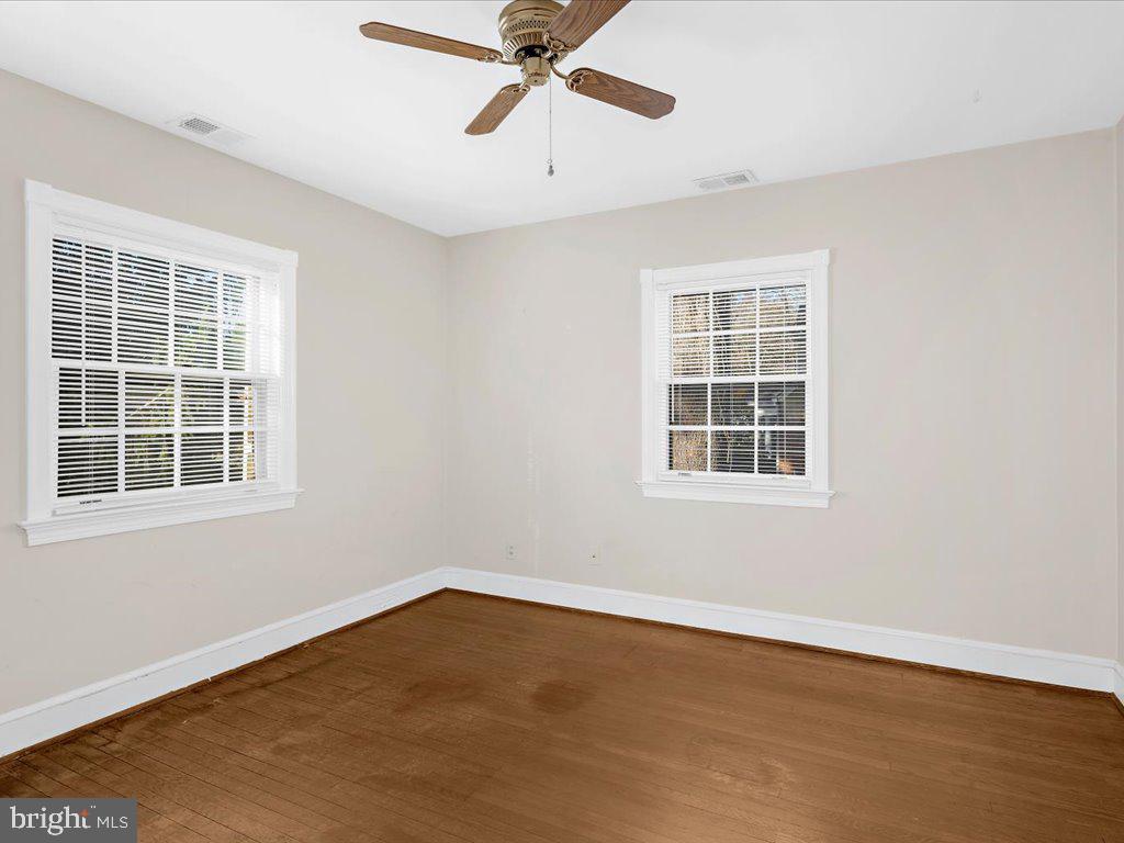 1201 Noyes Drive Silver Spring, MD 20910 - Photo 20 of 35 an empty room with wooden floor chandelier fan and windows