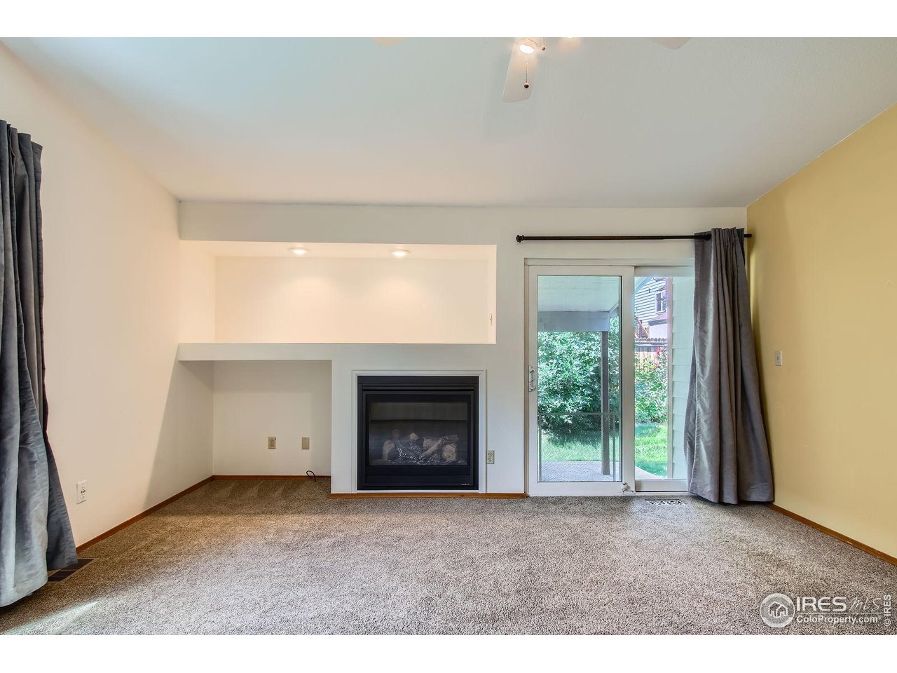 10947 West 100th Drive Broomfield, CO 80021 - Photo 12 of 38 a view of an empty room with a fireplace and a window