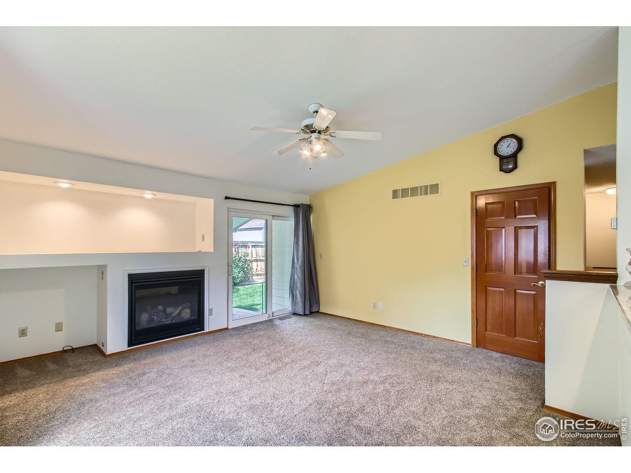 10947 West 100th Drive Broomfield, CO 80021 - Photo 13 of 38 a view of an empty room with a fireplace and a fan