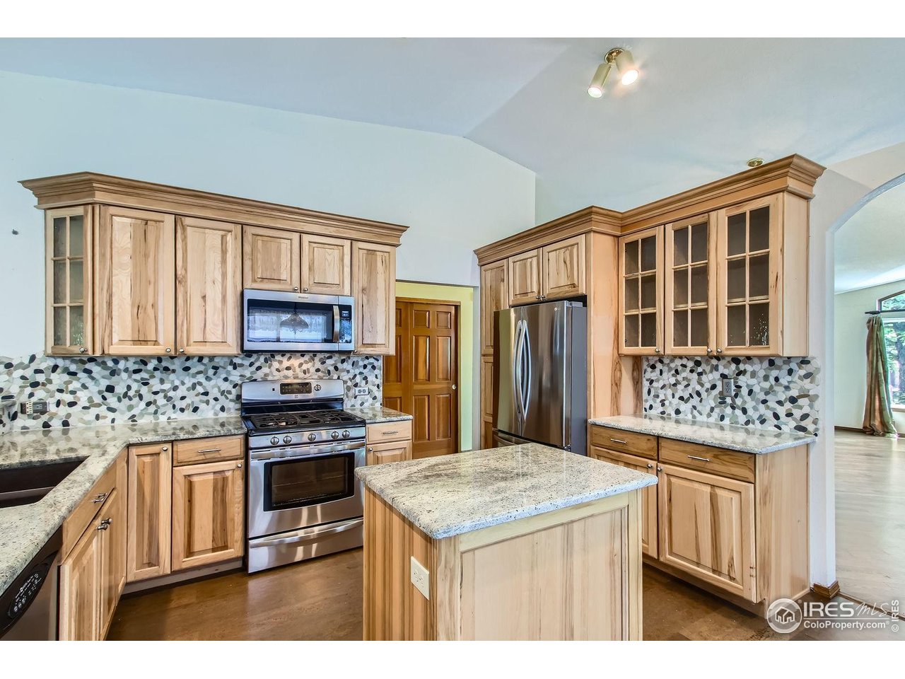 10947 West 100th Drive Broomfield, CO 80021 - Photo 4 of 38 a kitchen with stainless steel appliances kitchen island granite countertop a stove a sink and a refrigerator