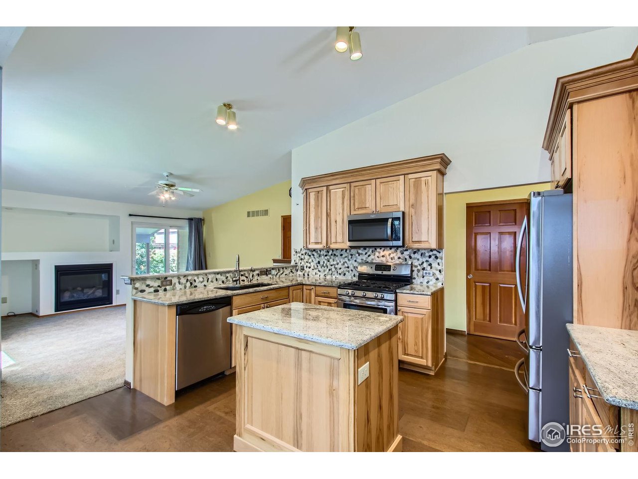 10947 West 100th Drive Broomfield, CO 80021 - Photo 5 of 38 a kitchen with a stove a sink and a refrigerator