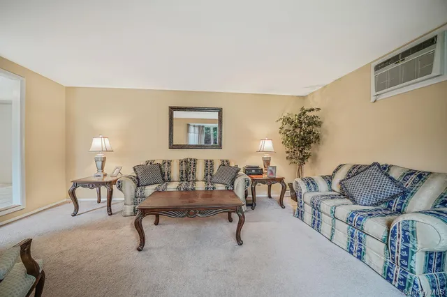 a living room with furniture and a potted plant on table