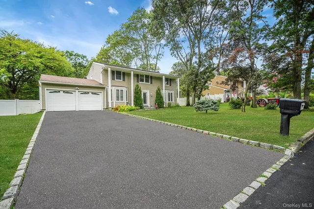 a front view of a house with a yard and trees