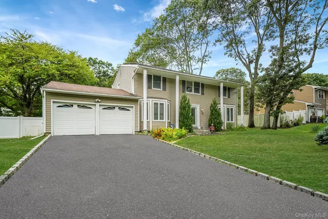 front view of a house with a yard and an trees