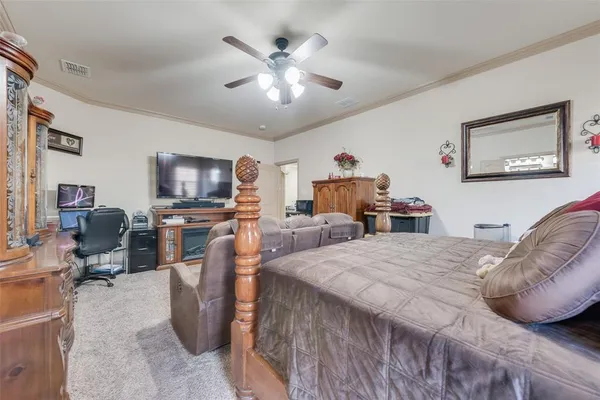 a bedroom with furniture a chandelier and a flat screen tv