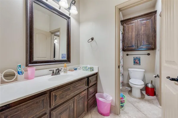 a bathroom with a sink and mirror with toilet