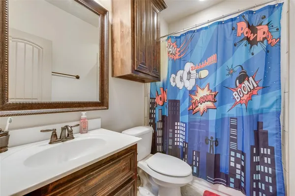 a bathroom with a sink a toilet and shower curtain