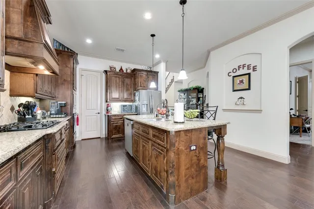 a kitchen with kitchen island a sink stove and wooden floor