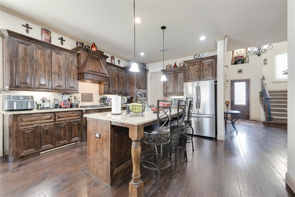5056 Empire Way Irving, TX 75038 - Photo 9 of 40 a kitchen with stainless steel appliances a dining table chairs stove and refrigerator