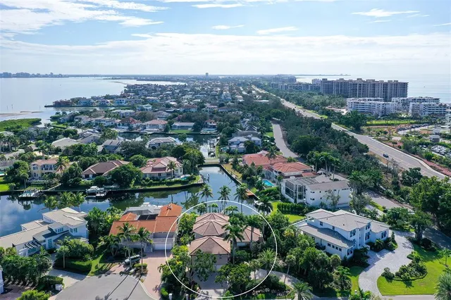 an aerial view of a city with lots of residential buildings ocean and mountain view in back