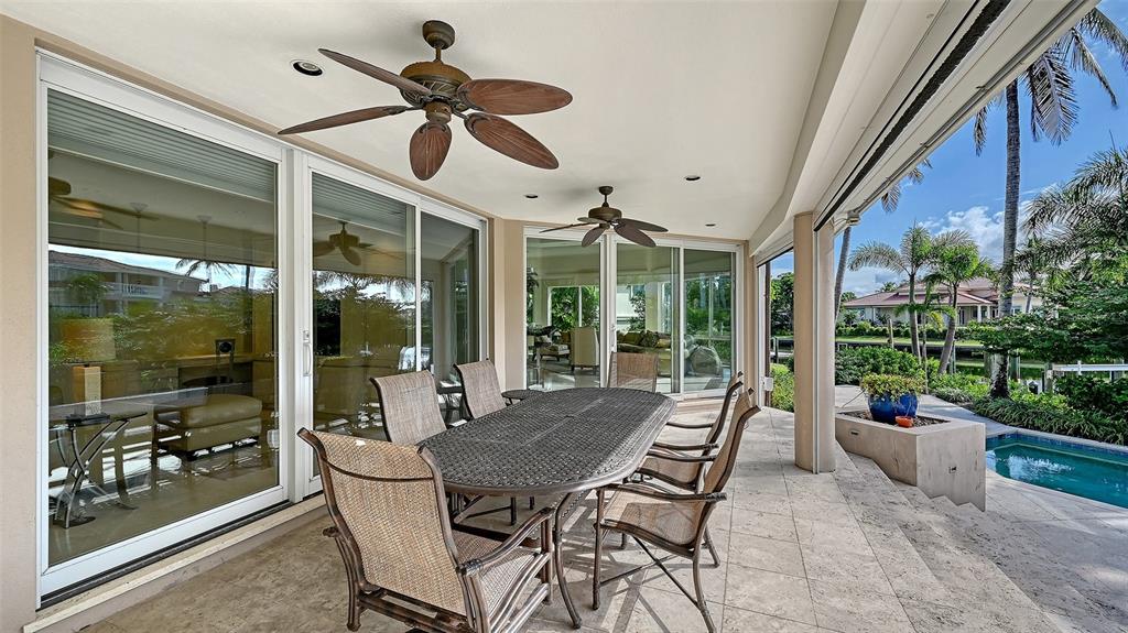 510 Harbor Gate Way Longboat Key, FL 34228 - Photo 60 of 98 a view of a patio with a dining table chairs and a floor to ceiling window