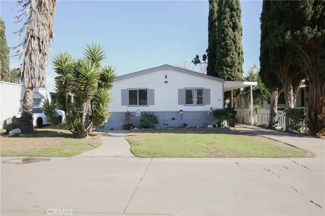 front view of house with a yard and potted plants