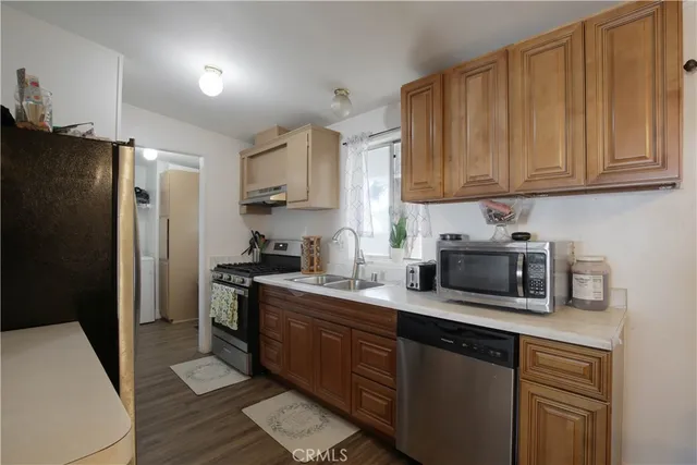 a kitchen with stainless steel appliances granite countertop a refrigerator stove top oven and sink