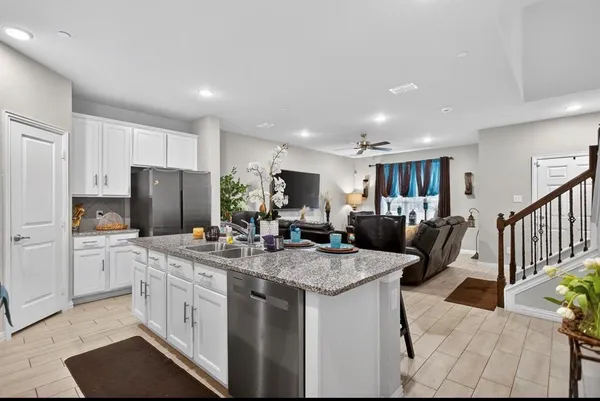 a kitchen that has a lot of cabinets a sink and a refrigerator in it