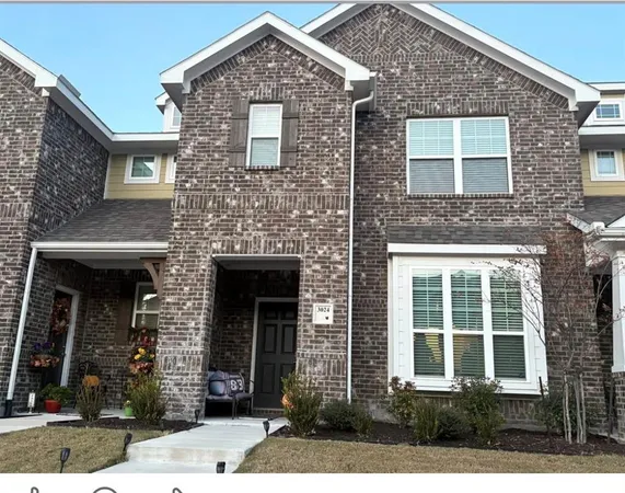 front view of a brick house with a small yard