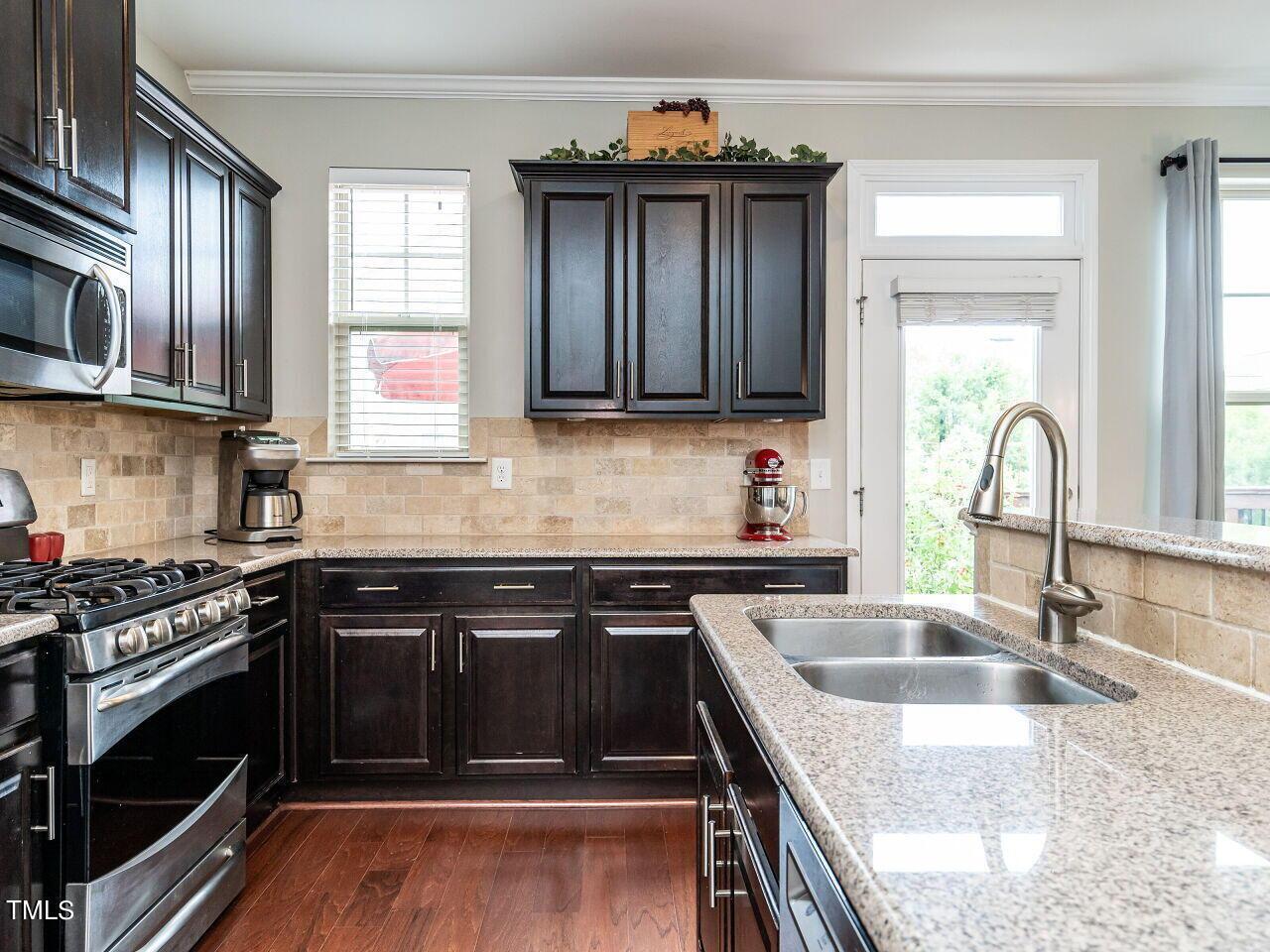 1316 Cornell Place Raleigh, NC 27607 - Photo 4 of 31 a kitchen with granite countertop a stove sink and cabinets