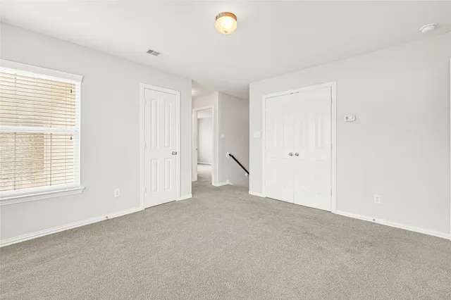 an empty room with windows and closet