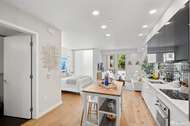 a view of a dining room and livingroom with furniture wooden floor a rug a fireplace and a window