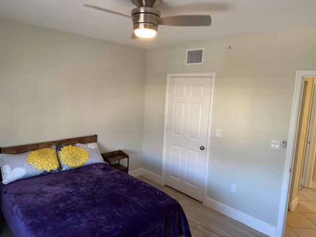 6400 Emerald Dunes Drive, Unit 301 West Palm Beach, FL 33411 - Photo 19 of 28 a bedroom with a bed and a chandelier