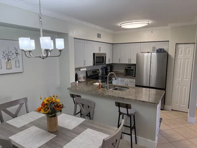 a kitchen with stainless steel appliances granite countertop a sink refrigerator and microwave