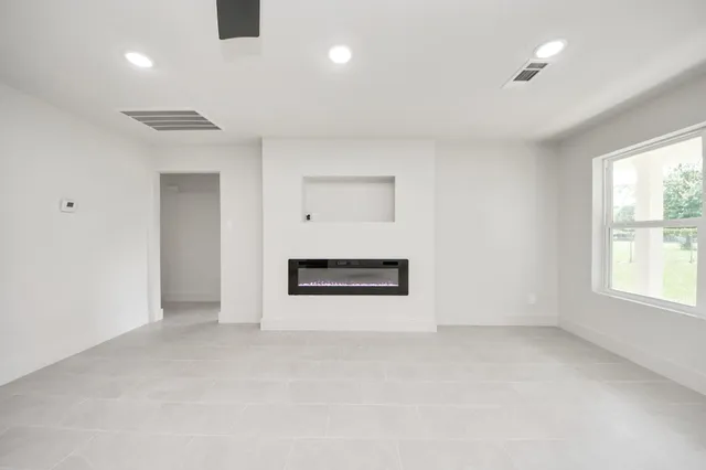 an empty room with windows and cabinet