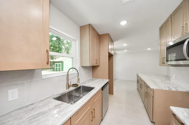 a kitchen with granite countertop a sink and a stove top oven