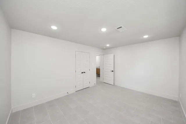 an empty room with closet and a ceiling fan