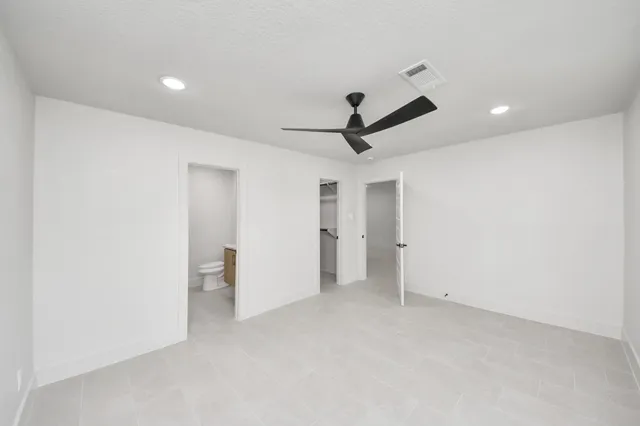 a bathroom with a granite countertop sink toilet and a mirror