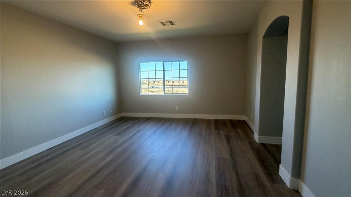 9453 Alma Ridge Avenue Las Vegas, NV 89178 - Photo 16 of 25 An inviting room features resilient vinyl plank flooring and an arched doorway leading to another space.