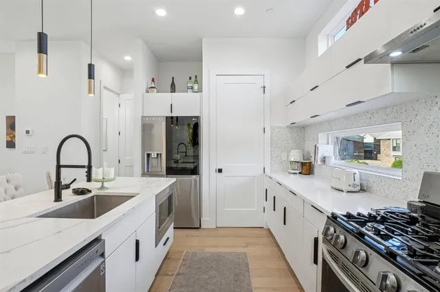 a kitchen with stainless steel appliances a sink stove and cabinets