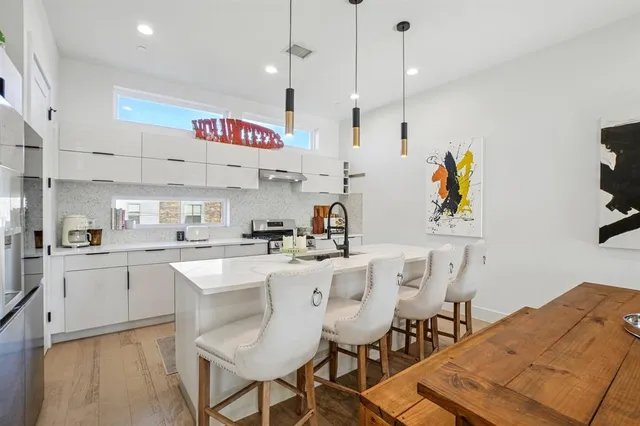 a kitchen with stainless steel appliances kitchen island granite countertop a sink and a refrigerator