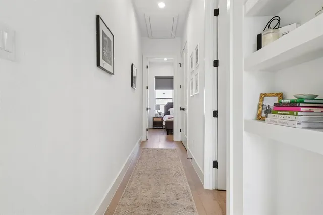 a view of a hallway with wooden floor and closet