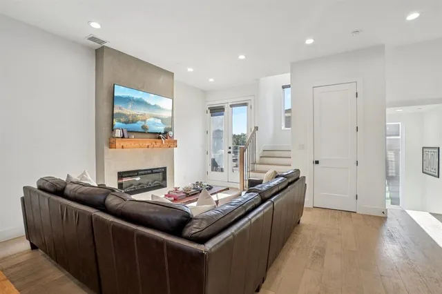 a living room with stainless steel appliances kitchen island granite countertop a sink and a refrigerator
