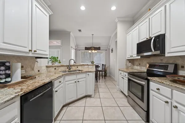 a kitchen with stainless steel appliances granite countertop a sink a stove a microwave and cabinets