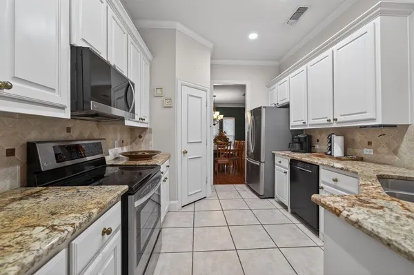 a kitchen with stainless steel appliances granite countertop a stove top oven a sink dishwasher a refrigerator and a microwave