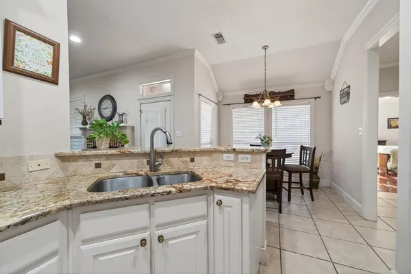 a kitchen with white cabinets and chairs