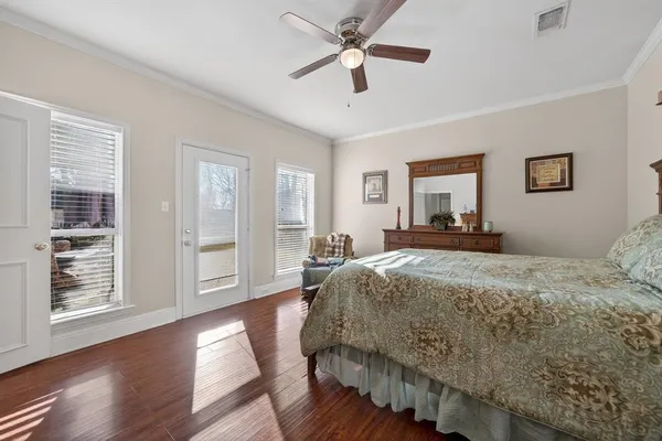 a bedroom with a bed ceiling fan and window