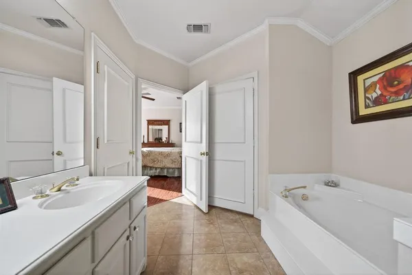 a bathroom with a tub a double vanity sink and mirror