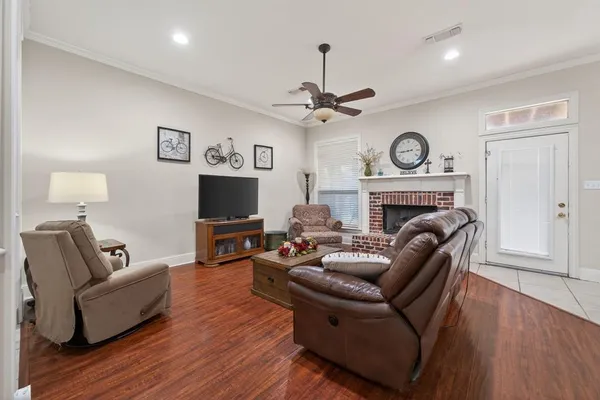 a living room with furniture a fireplace and a flat screen tv