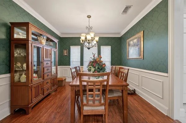 a dining room with furniture a chandelier and wooden floor