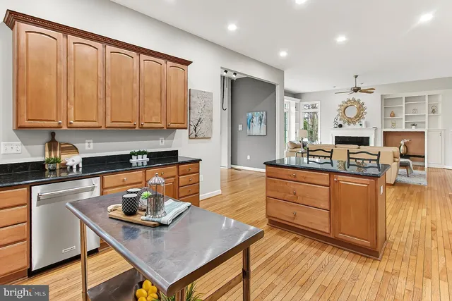 a kitchen with stainless steel appliances granite countertop a sink dishwasher stove refrigerator and cabinets