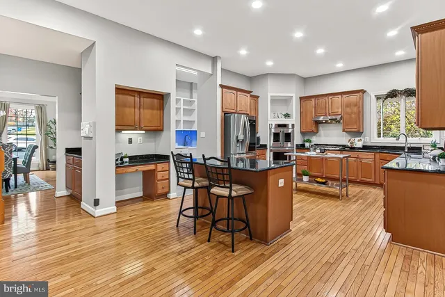 a kitchen with stainless steel appliances a table chairs refrigerator and a stove top oven