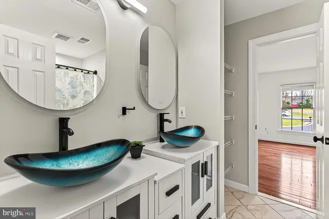 an empty room with a cabinet and mirrors