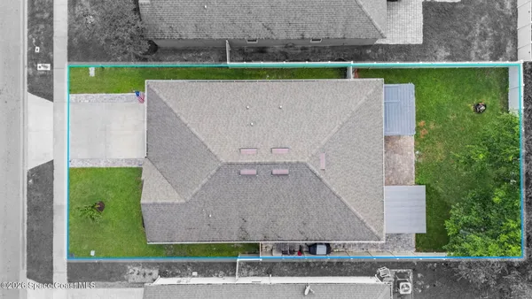 an aerial view of a house with a yard