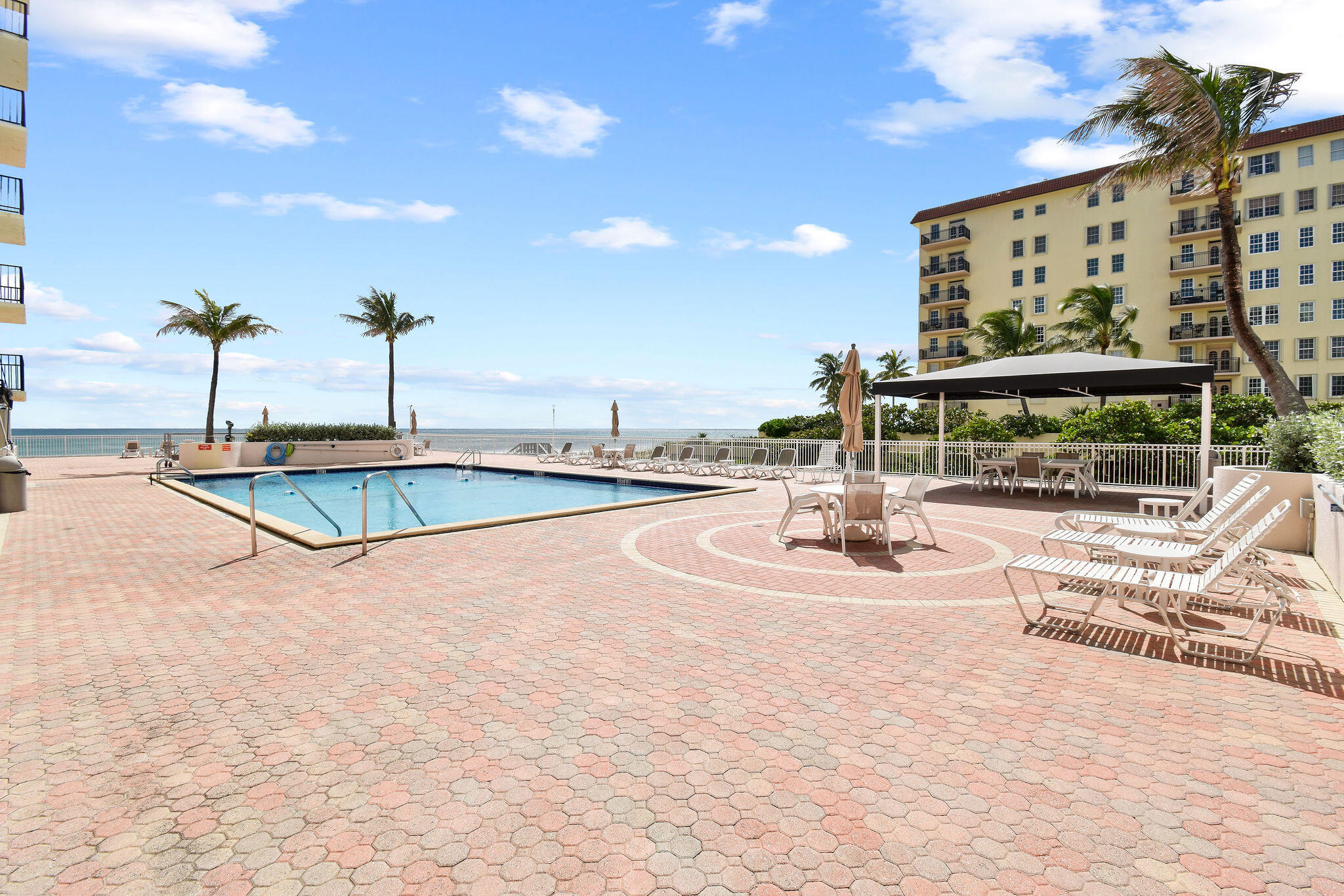 3460 South Ocean Boulevard, Unit 5100 Palm Beach, FL 33480 - Photo 28 of 42 a view of a swimming pool with a lawn chairs