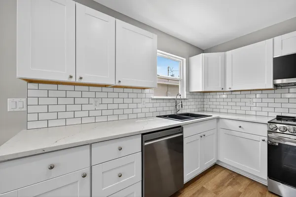 a kitchen with a stove a sink and a microwave